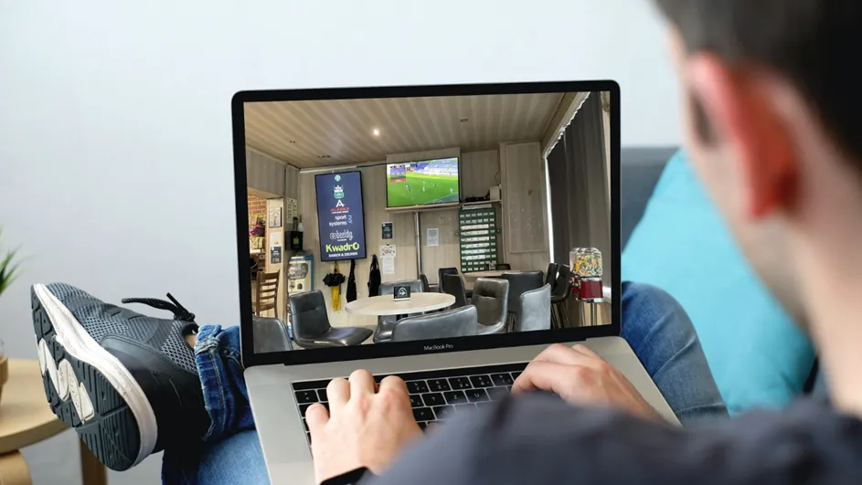 Een sfeerfoto van een persoon die op zijn laptop bezig is.
