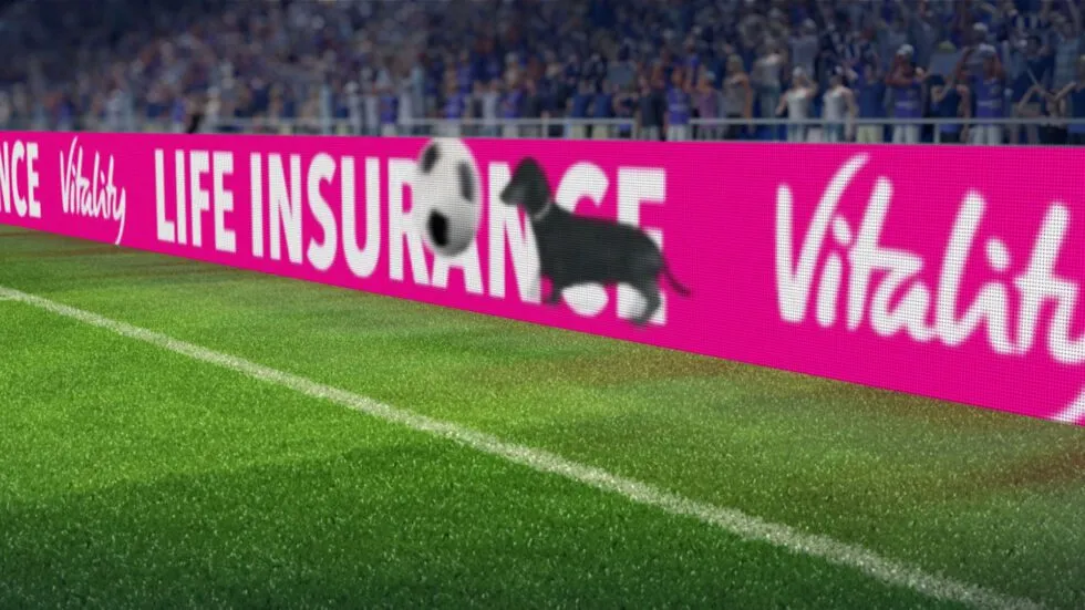 Een foto van de rand van een voetbalveld met LED-borden.